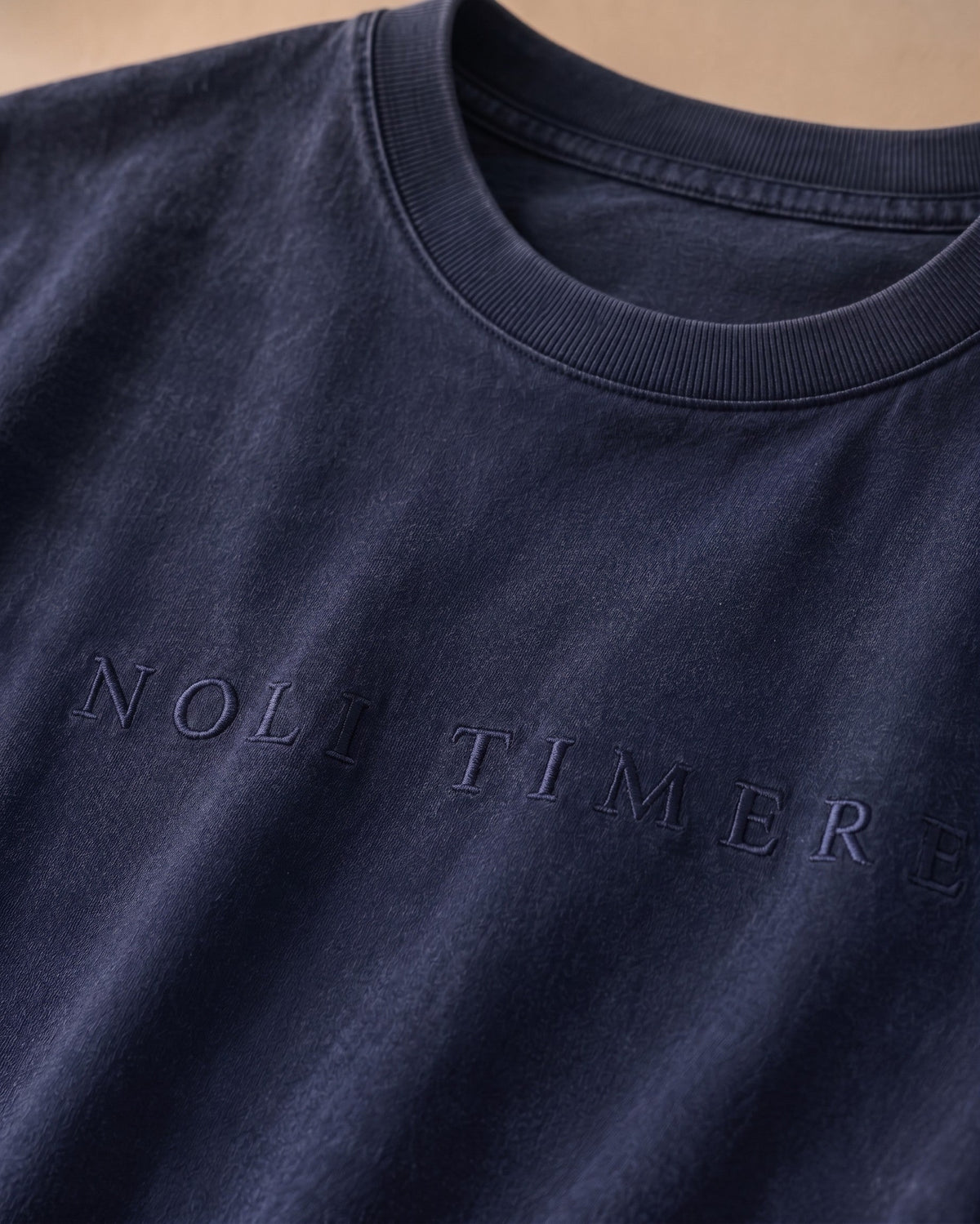Polera Lavada 180 gr · Azul (últimas unidades) - detalle del bordado NOLI TIMERE
